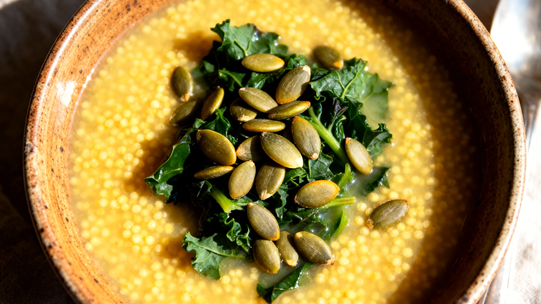 Zuppa di miglio con verdure amare e semi di zucca"